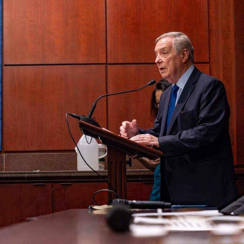 The image is of Senator Durbin at the press conference