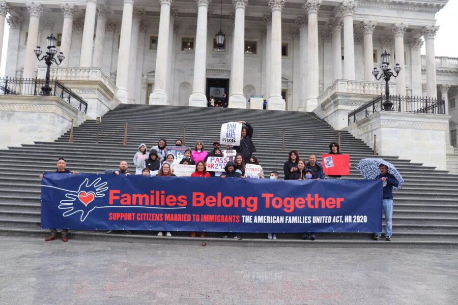 This is an image of people holding a long sign that reads, "Families Belong Together".